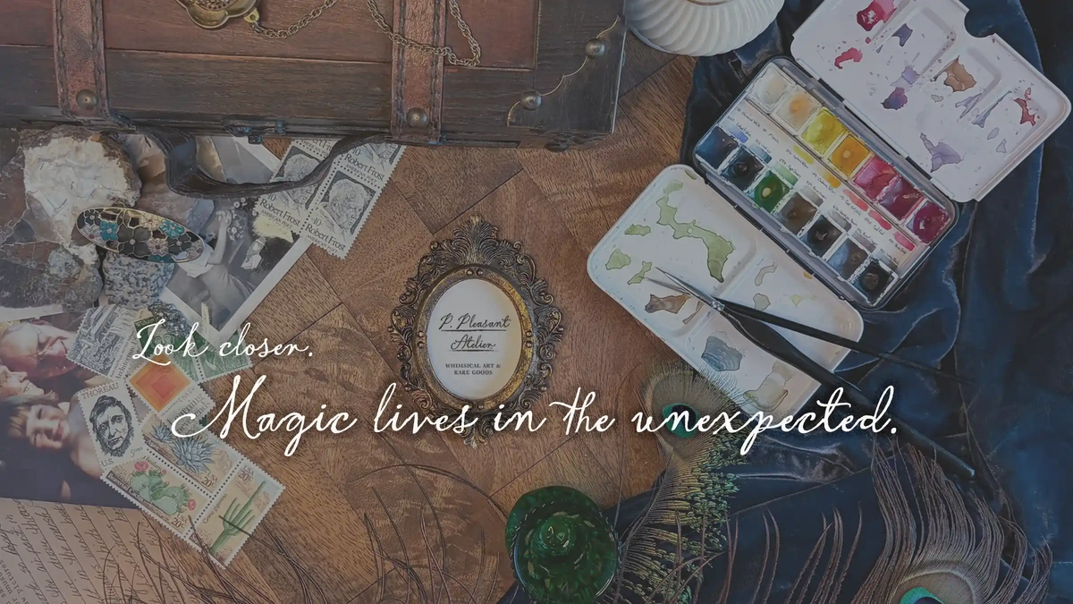 A styled flat-lay scene with vintage postcards, an antique leather trunk, a watercolor paint palette, a small framed label reading 'Le Gourmet des Dits', and overlaid cursive text that says 'Look closer. Magic lives in the unexpected.