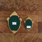 Art display with two fairy themed framed plaques, green leather panels on a wooden wall with gold edges
