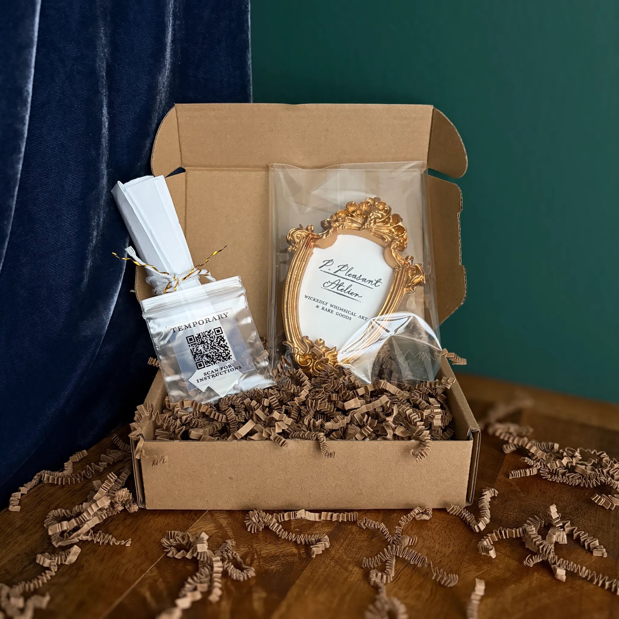 Art fairy magic themed gift box with a gold framed card, wrapped in clear plastic and set on shredded paper