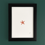 Art frame on a teal wall with a small red starfish drawing, leaving most of the canvas blank