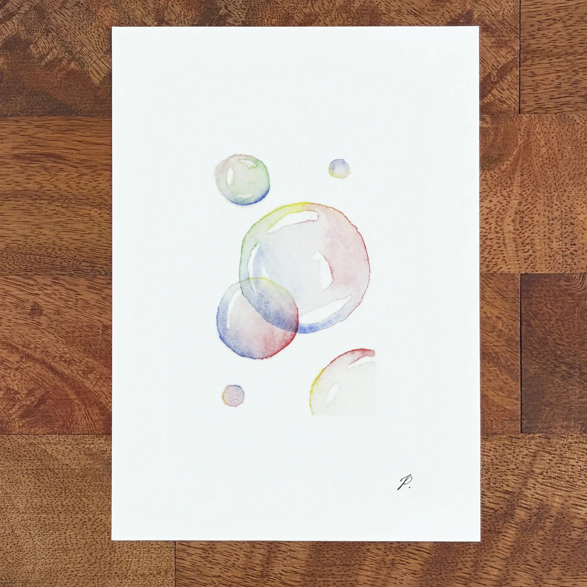 Art of a fairy with watercolor planets and small bubbles on a white sheet on a wooden table