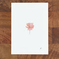 Art fairy magic theme card with a pink flower illustration on a white page atop a wooden table